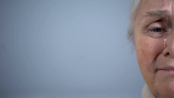 Half-Face of Upset Crying Elderly Woman Isolated on Grey Background Hopelessness