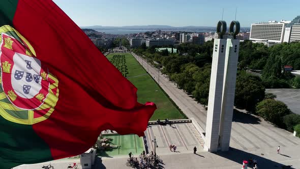 Close Up Aerial View of Portugal Flag Waving in the Wind on Eduardo VII Park Lisbon