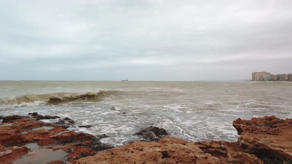 Storm Surge Waves Spill Over Harbor Sea Wall. 