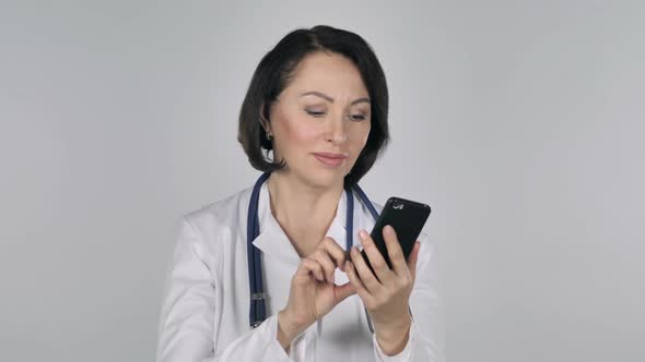 Lady Doctor Browsing Smartphone White Background