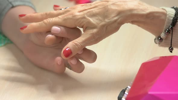 Beautician Applying Oil on Manicured Nails.