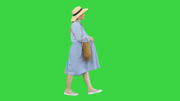 Pregnant Woman in Summer Clothes Walking with Shopping Bags on a Green Screen, Chroma Key.