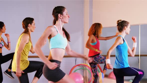 Woman smiling while performing aerobics exercise with the team