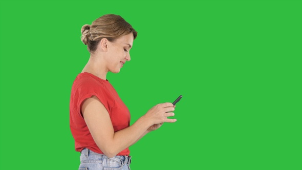 Pretty woman using cell phone on a Green Screen, Chroma Key.