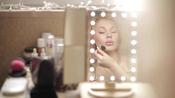 Blonde Looking at Mirror and Doing Makeup at Home