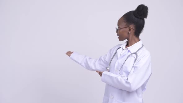 Young Happy African Woman Doctor Showing Something