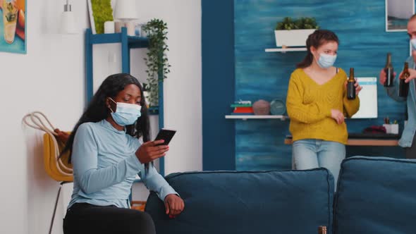 Diverse Friends Hanging Out in Living Room Watching Clip on Smartphone