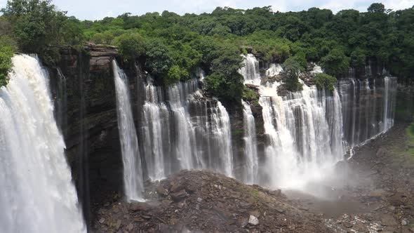 Pan from streams of water falling down at the Kalandula Falls in Angola