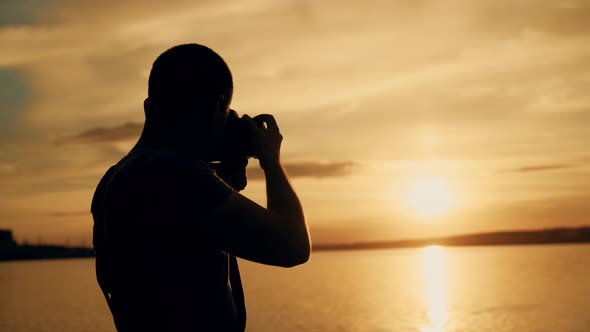 Man Looks at the Photos in the Camera