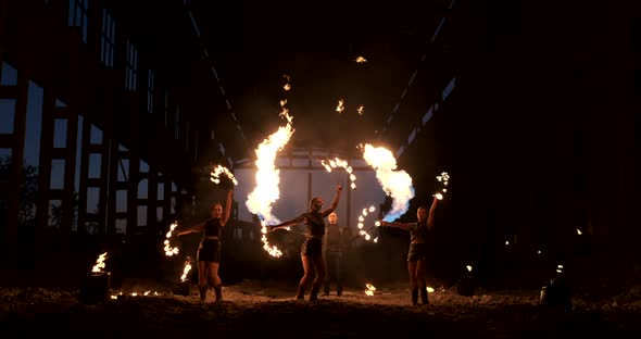 A Group of Professional Artists with Fire Show the Show Juggling and Dancing with Fire in Slow