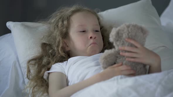 Miserable Little Girl Lying in Bed Alone With Eyes Full of Tears, Missing Mummy