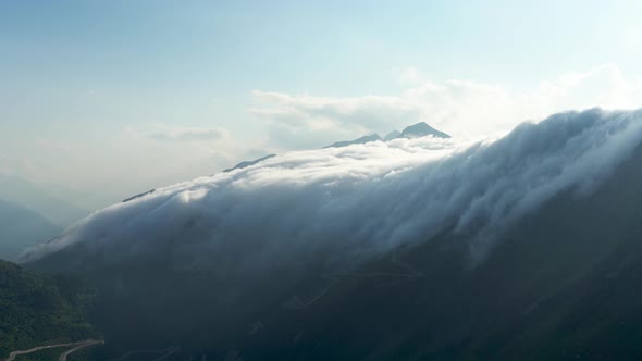 Clouds slide down the mountains like a waterfall in the Swiss Alps, Switzerland.