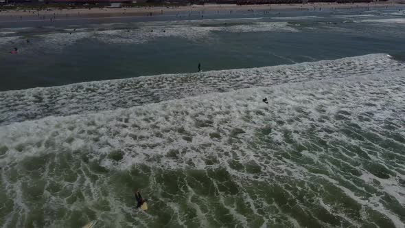 Drone shot of surfers at Muizenberg beach, Cape Town - drone is following a fliteboard surfer from b