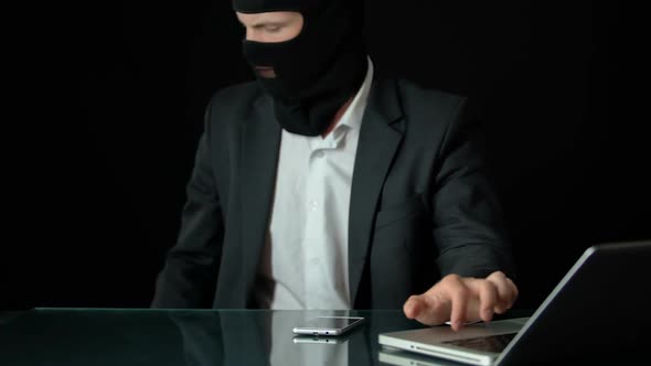 Gun-Man in Balaclava Using Computer, Preparing for Attack, Blackmail Crime