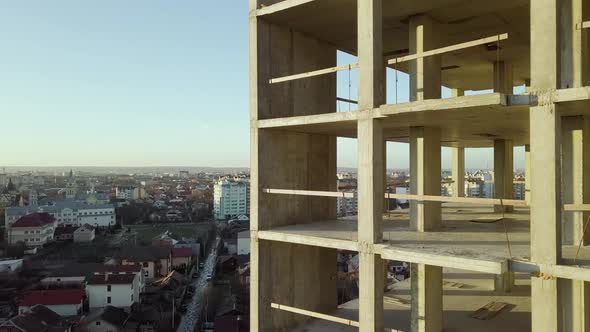 Concrete interior frame of tall apartment building under construction in a city.