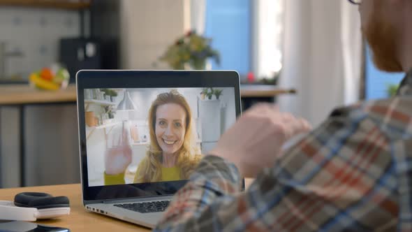 Back View of Man Video Calling To Mature Woman on Laptop From Home