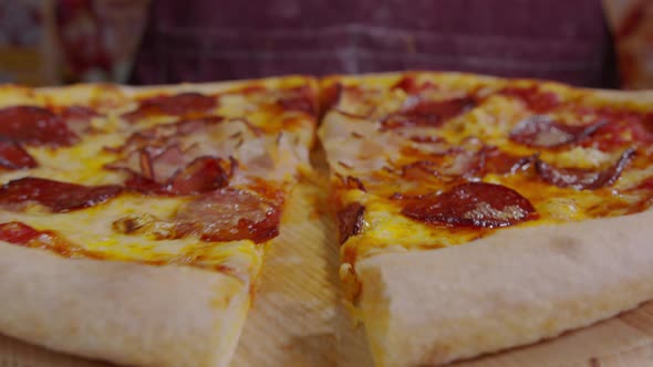 Cutting Pizza with a Round Cutter Knife. Close-up of Delicious Pizza Being Cut Into Pieces. Slow