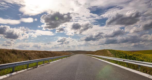 White Cumulus Clouds Float Over the Highway