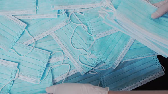 Background with Medical Masks. Time-lapse Fast-moving, a Glove Nurse Puts Medical Masks on a Black