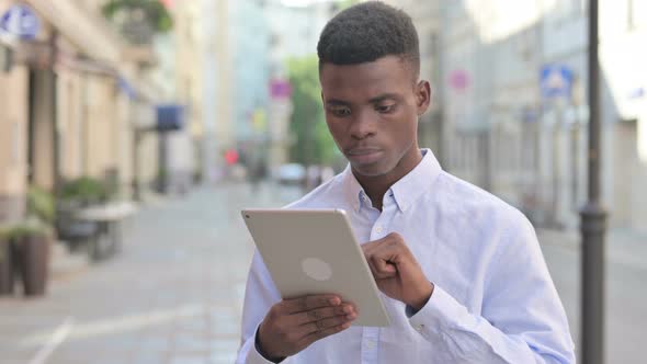 Attractive African Man Using Tablet in Street