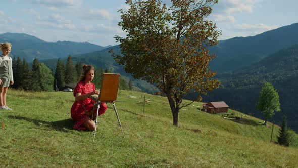 Creative Woman Drawing Picture in Mountains