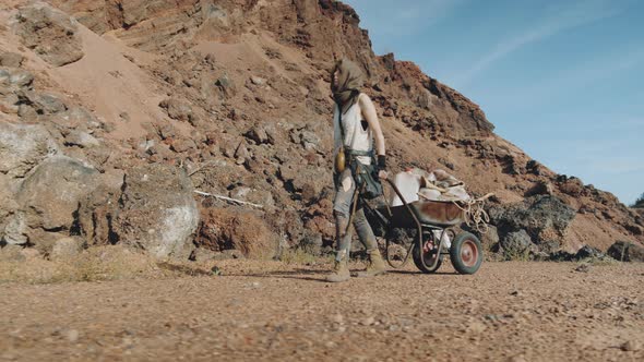 Woman Going with Cart in Post Apocalyptic Desert