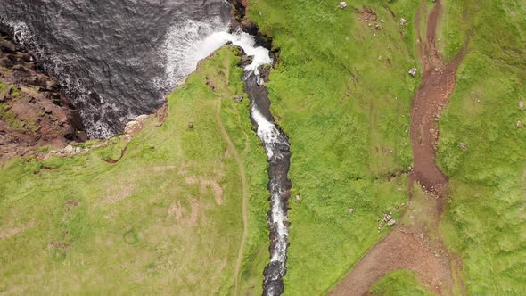 Stunning Waterfall Splashing From Cliff Aerial View. Mulafossur Waterfall Near Gasadalur Village at