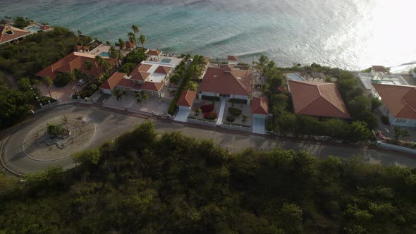 Aerial trucking shot of the waterfront houses on the tropical island