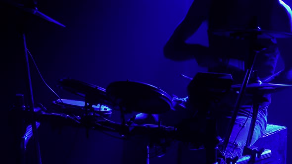 Professional Musician Playing Drums and Percussion Cymbals in a Dark Smoky Studio with Blue Lights