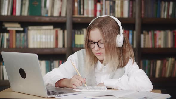 Young Female Pupil Watching Lesson Online and Studying From Home