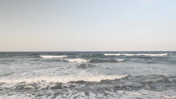 Waves hitting the sand on a black sand beach.