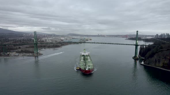 Barge and pilot boat sailing on Burrard Inlet fjord under Lions Gate Bridge, Vancouver in Canada. Ae