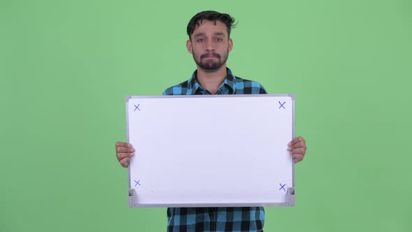 Stressed Young Bearded Persian Hipster Man Holding White Board