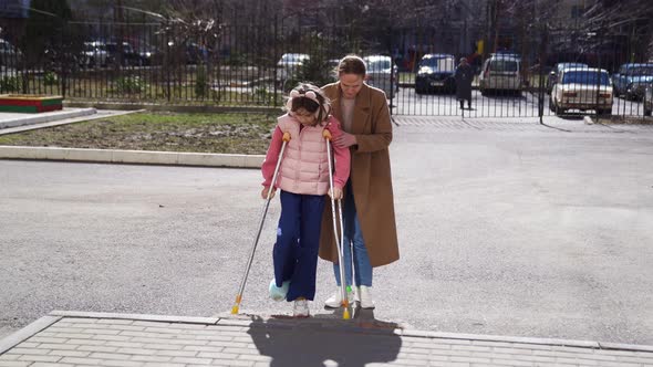 Mom Helps Her Daughter Learn to Walk on Crutches