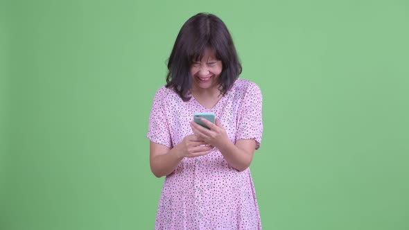 Happy Asian Pregnant Woman Using Phone