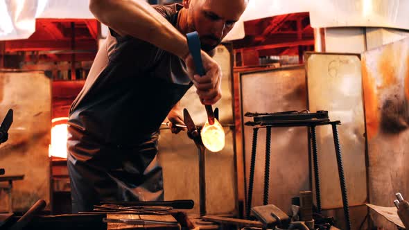 Glassblower shaping a molten glass