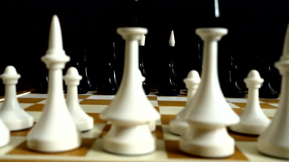 Chess on a chessboard. Shooting on a black background.