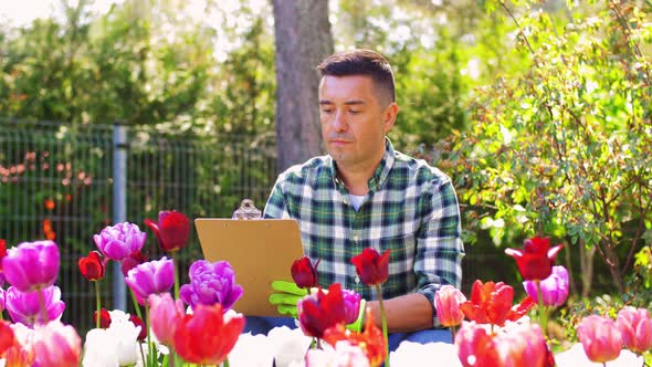 Man with Clipboard and Flowers at Summer Garden