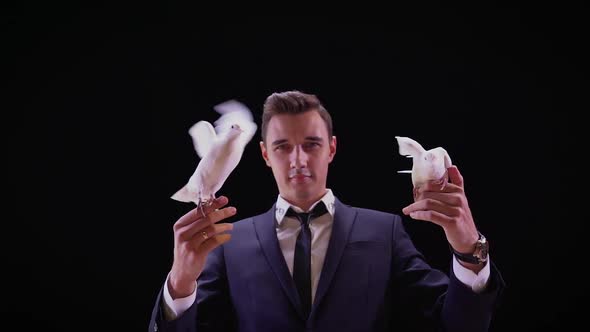 Magician with Pigeons. Shows Focus with Two White Pigeons. Magician Releases Dove From Hands, Slow