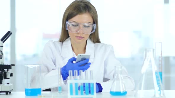 Female Scientist Using Smartphone in Laboratory