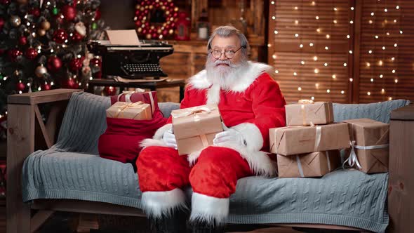 Cheerful Male in Santa Claus Costume Posing with Gift Box