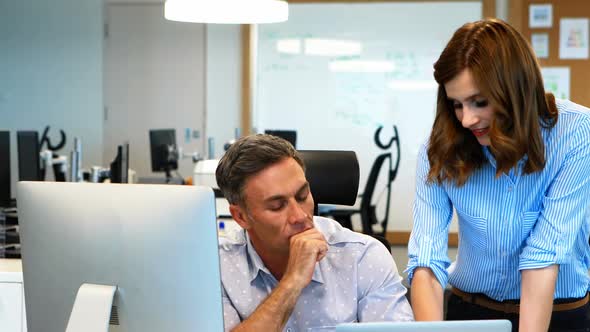 Business colleagues working on computer and laptop at desk