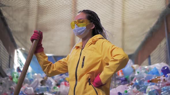 Portrait of a Girl with Dreadlocks in Yellow Jacket and Mask Holding Large Duck Shovel Standing at a