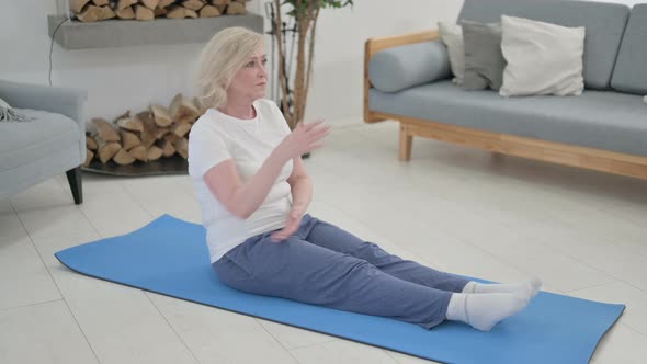 Senior Old Woman Doing Stretches on Yoga Mat at Home