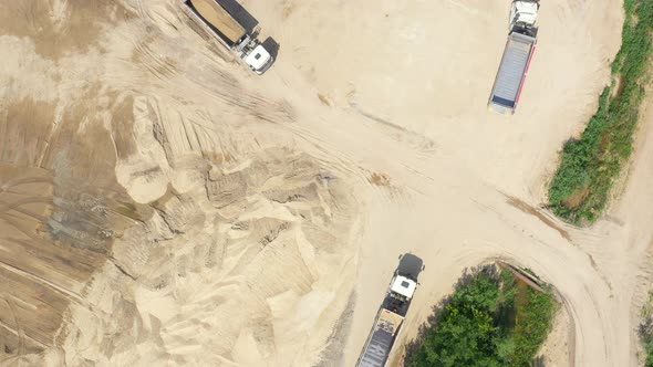 Aerial view, machinery working at clay quarry, heavy loaders, large trucks, bulldozers, excavators,