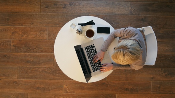 Young woman using laptop while sitting at cafe