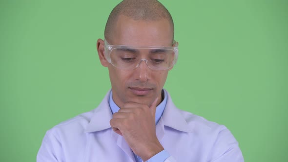 Face of Stressed Bald Multi Ethnic Man Doctor with Protective Eyeglasses Thinking