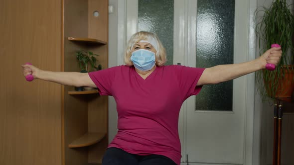 Senior Elderly Caucasian Woman Making Weightlifting Dumbbells Exercising at Home During Coronavirus