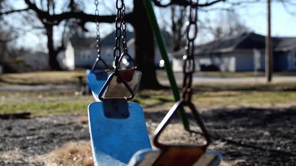 Empty swings swaying in a school playground