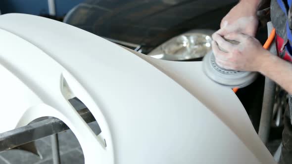 Mechanic Prepares the Car Body of the Car for Painting. Grinding the Car Body